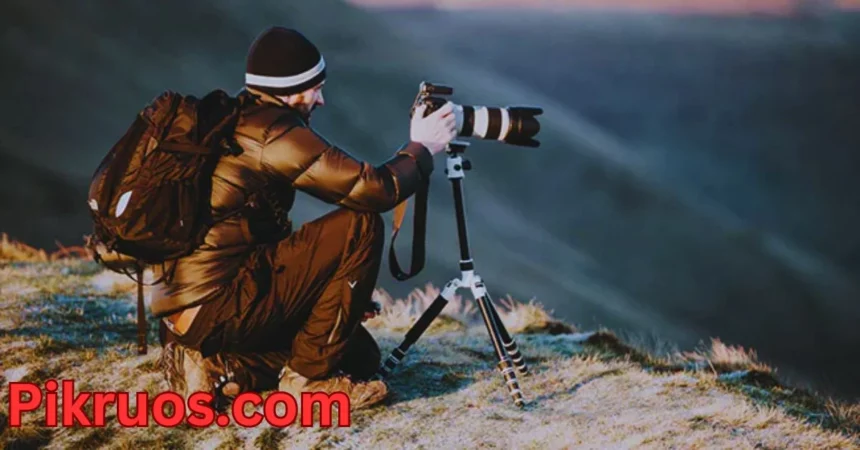 a person sitting on a hill with a camera